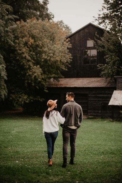 Laura and Timmy walking hand in hand across the lawn in front of their home.